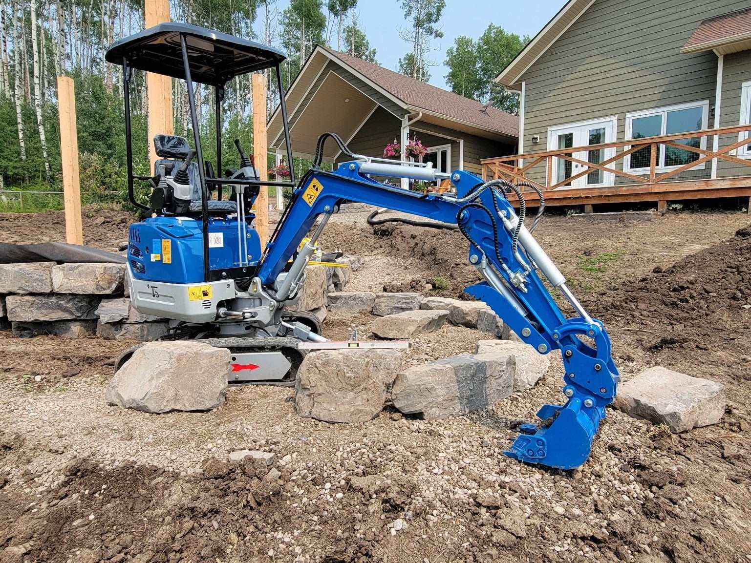 1.2 ton mini excavator for rent in Calgary by JoyT5 compact excavator JT5120 working on a landscaping and construction project in Alberta, Canada.