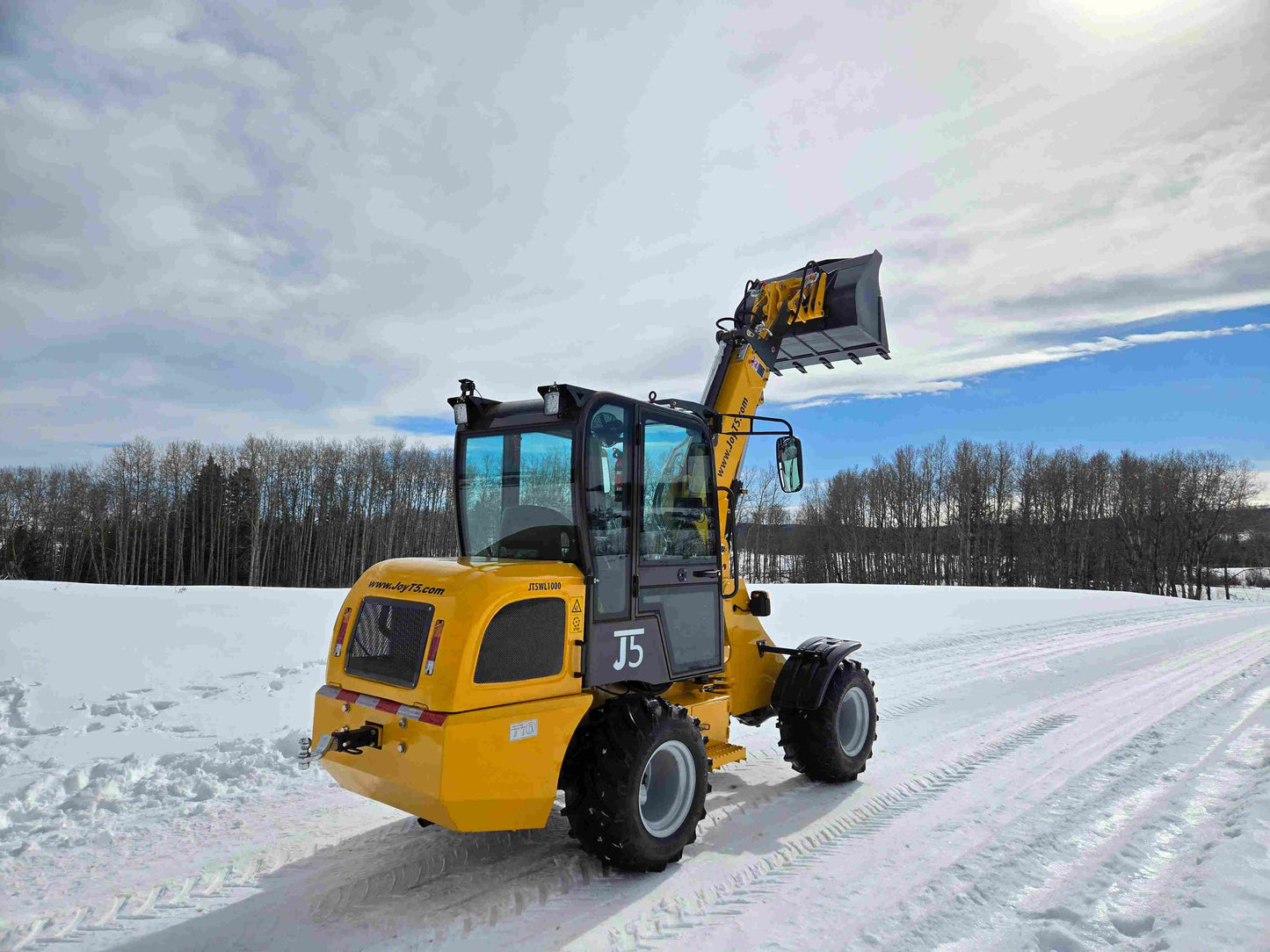 JT5WL1000 compact wheel loader 1 ton 2200 lbs side rear view with bucket lifted on snow field