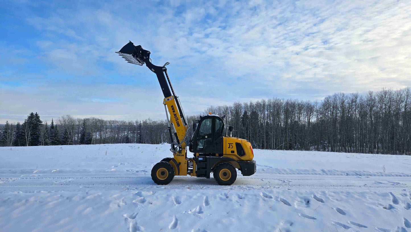 JT5WL1500 compact wheel loader side profile with fully raised bucket on snowy terrain.
