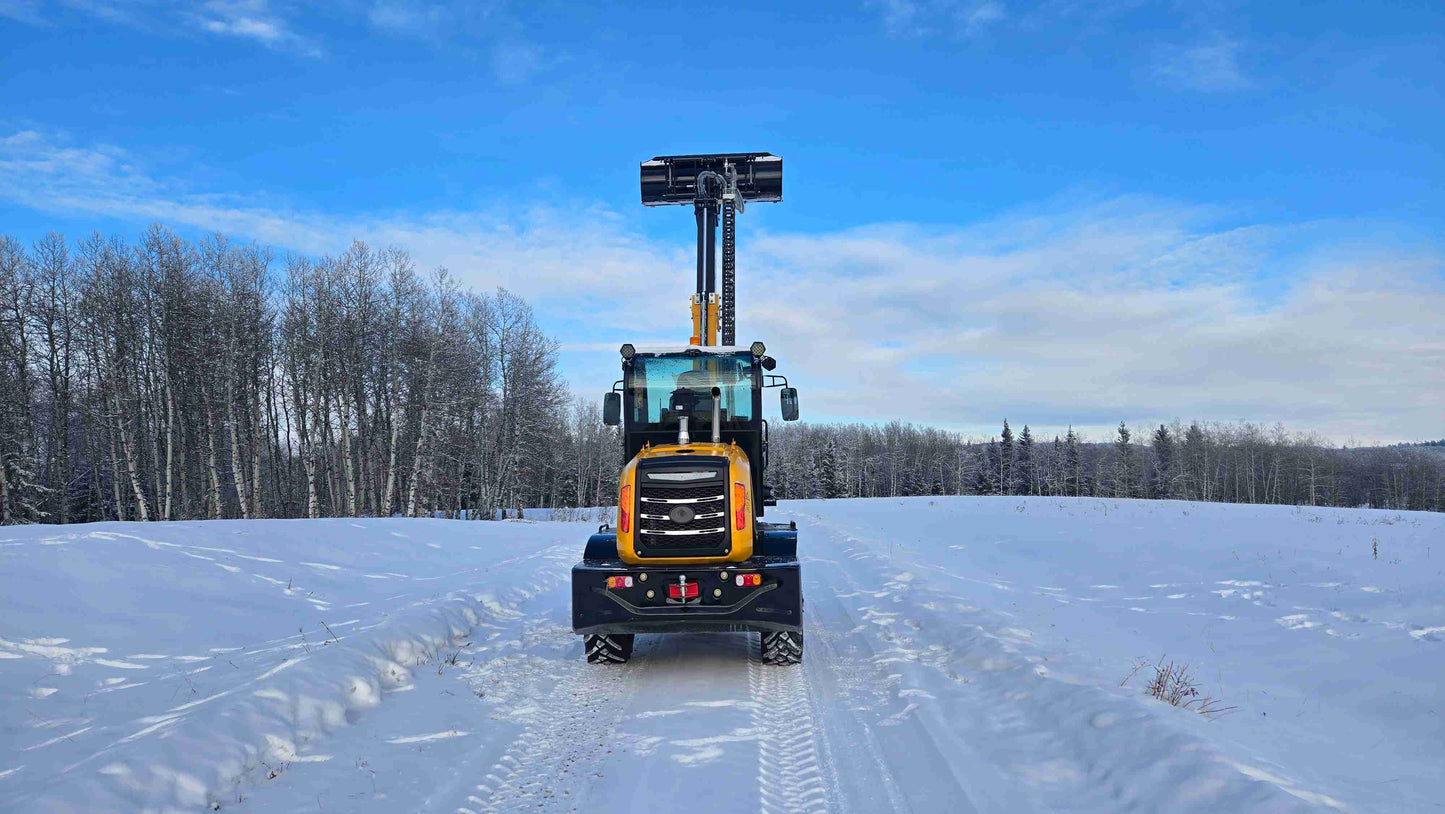 JT5WL1500 wheel loader rear center view with extended boom and raised bucket on a snowy field.