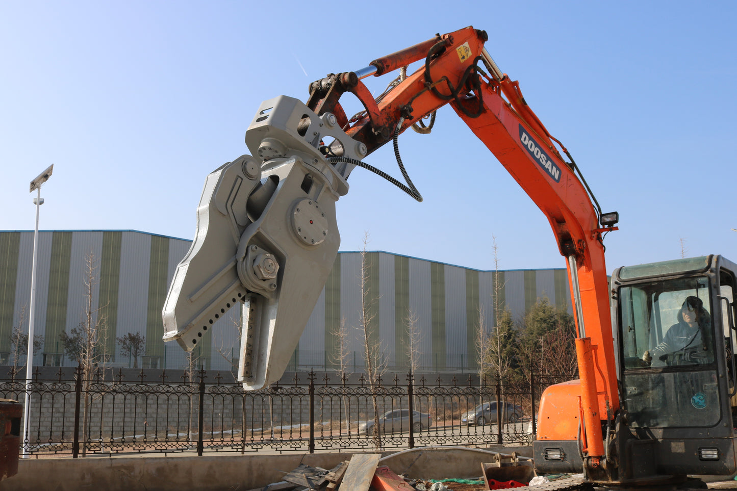 Excavator hydraulic rotating shear attachment wrapped for protection before installation.