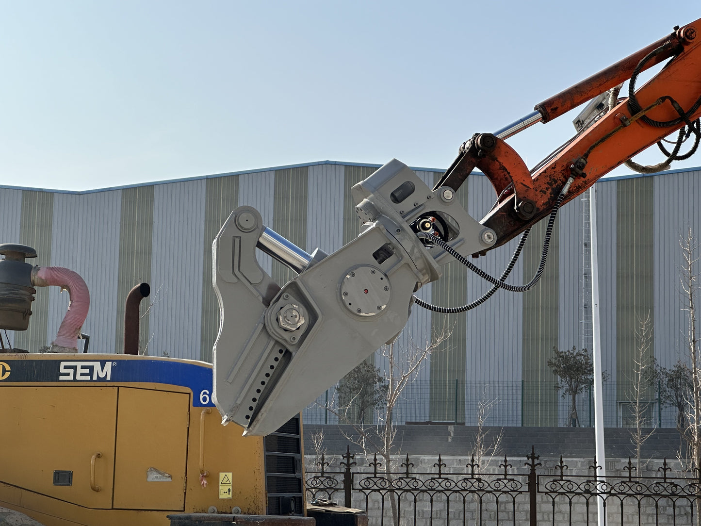 Close-up view of excavator rotating hydraulic shear attachment for heavy demolition.