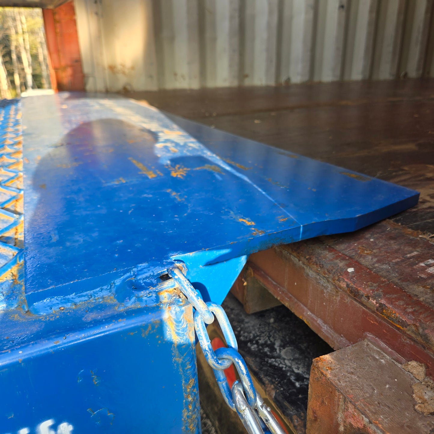 JoyT5 12 ton heavy duty steel loading ramp in Canada securely connected to shipping container for safe forklift and truck loading operations.