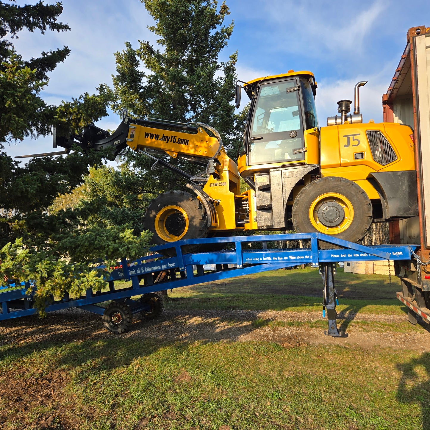 Side view of JoyT5 12 ton heavy duty mobile loading ramp in Canada used for forklift loading heavy equipment into container truck.