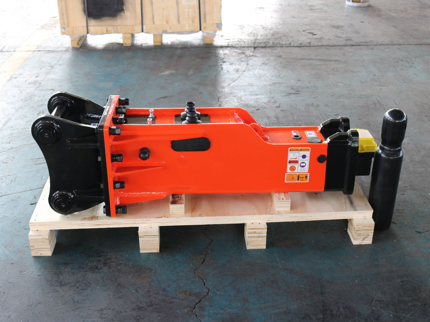 Durable orange JoyT5 hydraulic breaker hammer attachment for excavator on wooden pallet, heavy-duty construction equipment tool