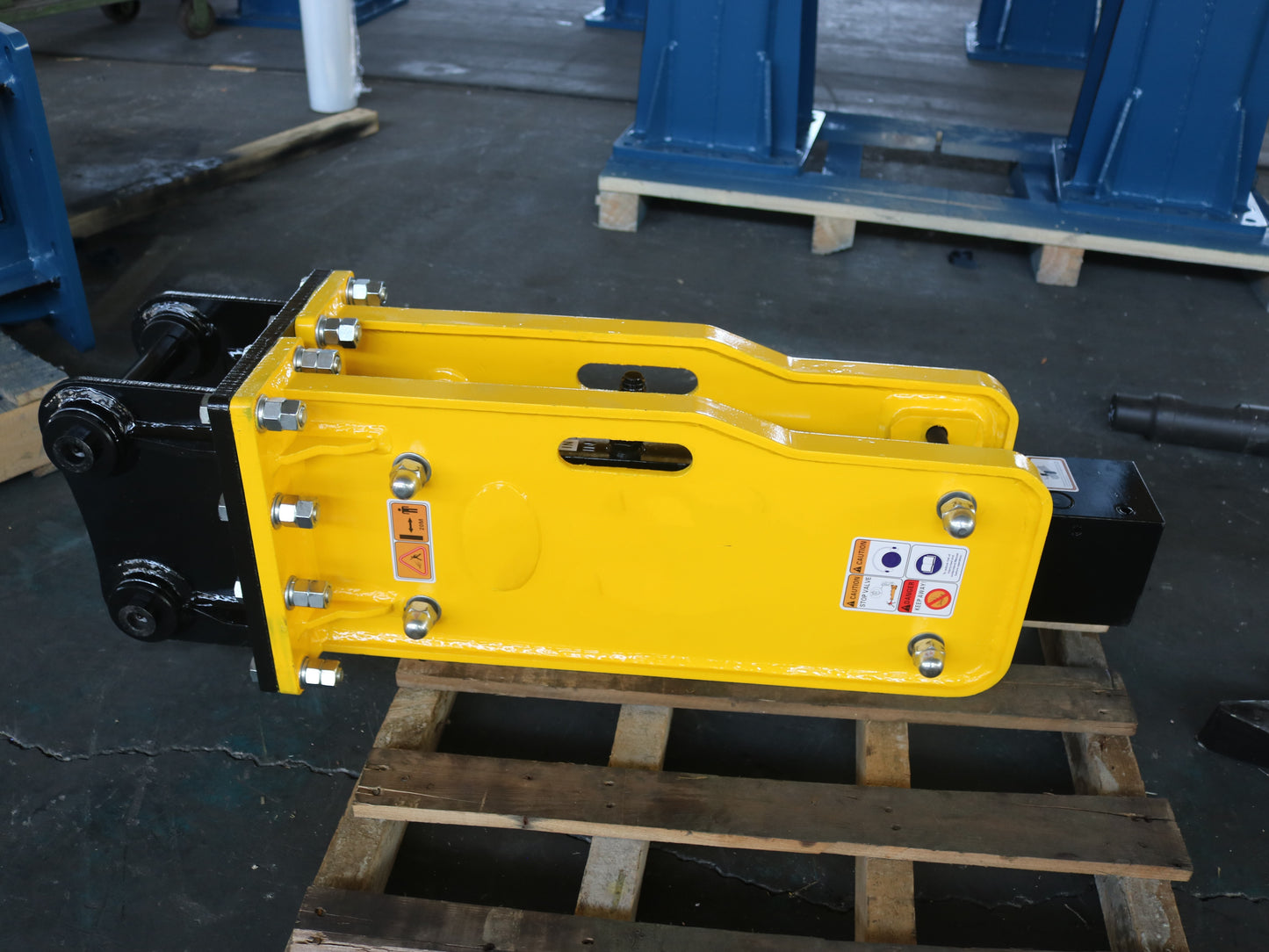 Heavy-duty yellow JoyT5 hydraulic breaker hammer attachment for excavator on wooden pallet, durable construction equipment part.