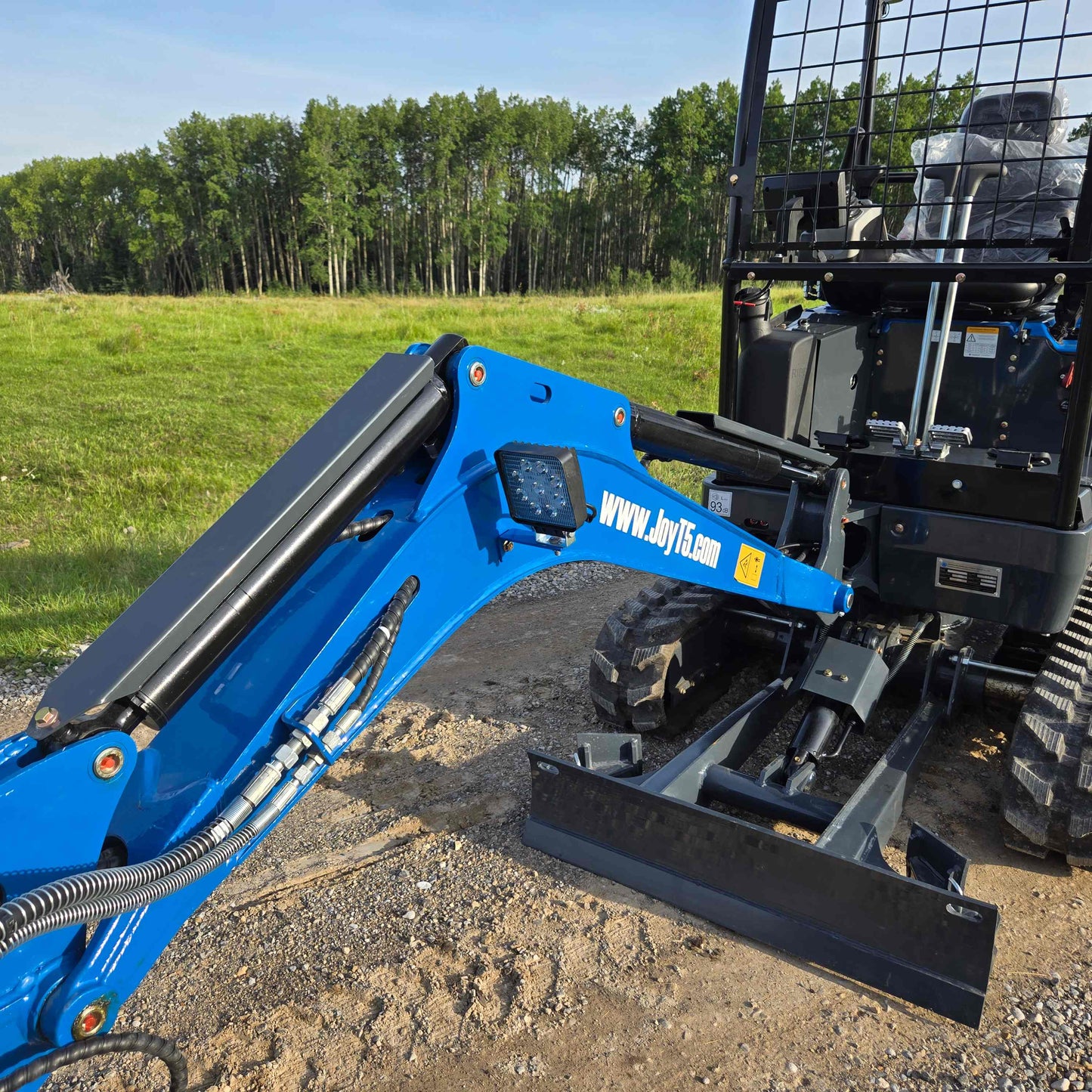 Close-up view of JoyT5 Rippa R18 Mini Excavator showing hydraulic arm, front blade, and operator cabin