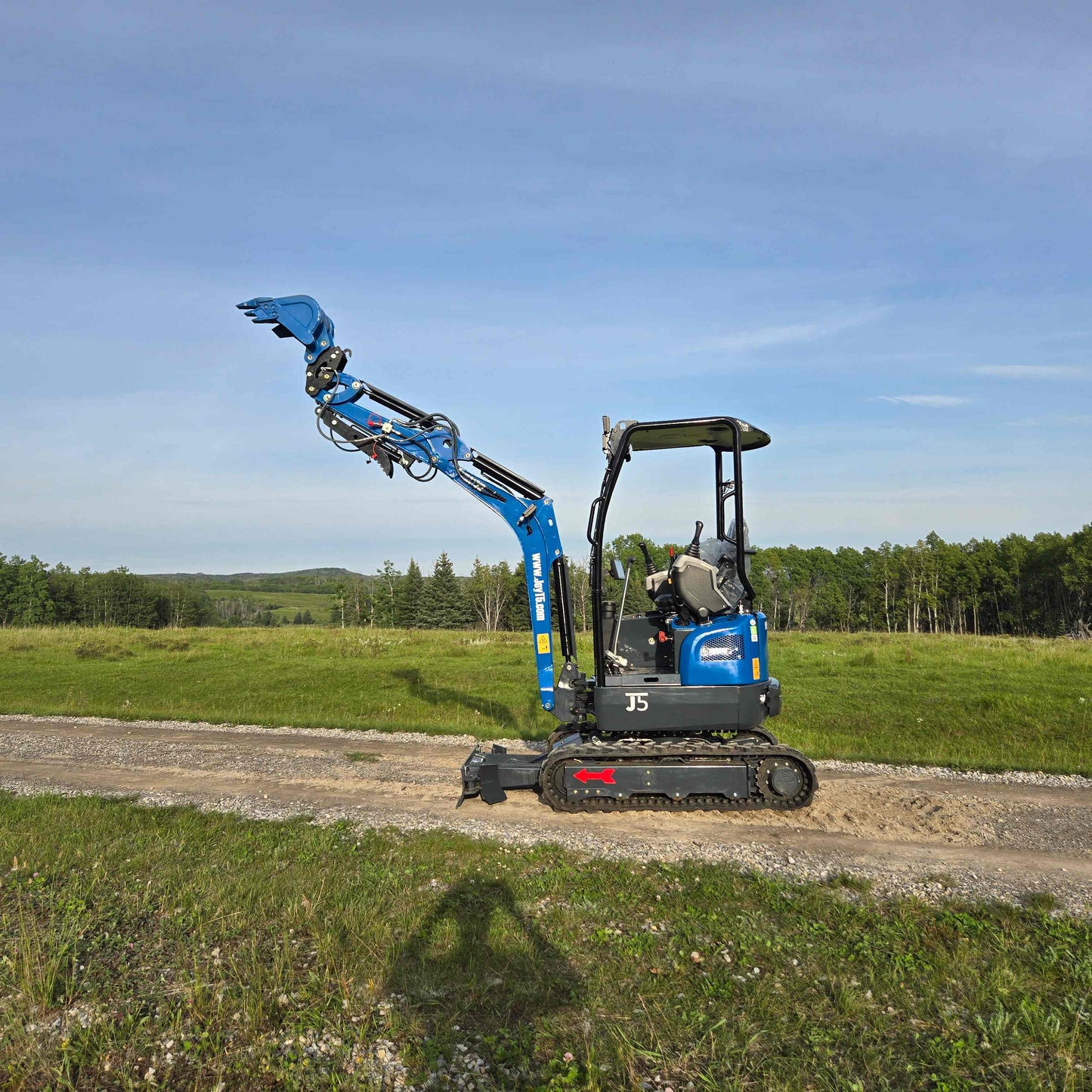 JoyT5 Rippa R18 Mini Excavator side profile on gravel road with raised bucket