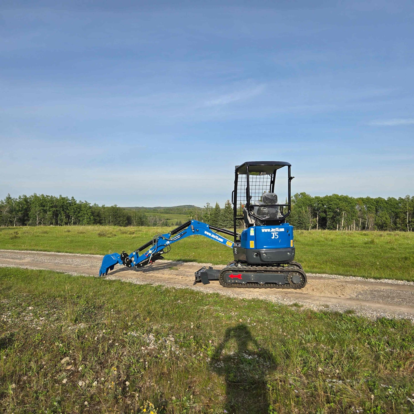 JoyT5 Rippa R18 Mini Excavator with bucket extended forward working on a dirt path in the field