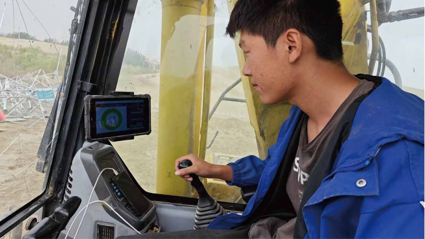 Excavator operator using JT5 ATS in‑cab torque and alignment monitor EM‑10W – wireless construction display showing real‑time torque and angle data for helical pile installation and drilling applications.