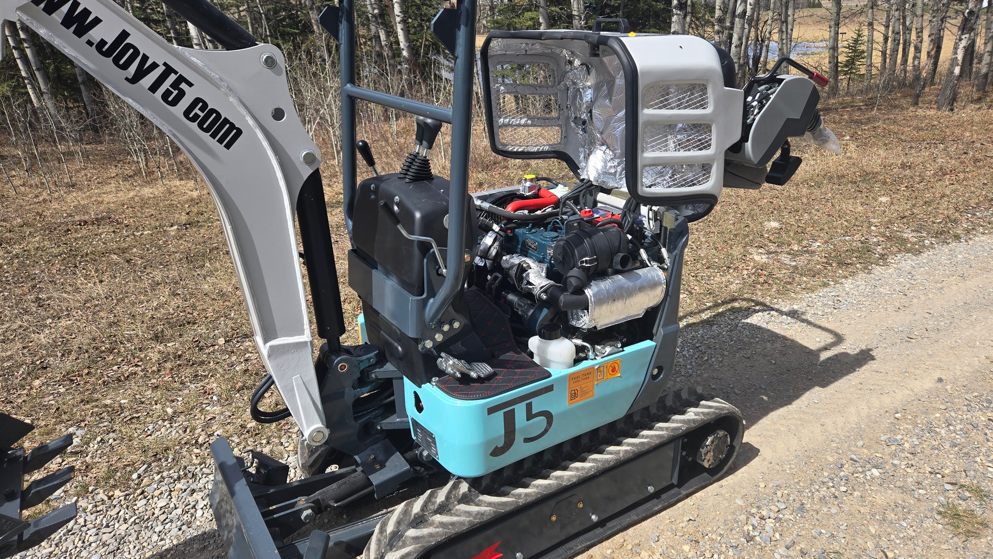 JT5120P 1.2 ton mini excavator with Kubota D722 engine open engine cover showing internal components and compact zero tail design for sale in Canada