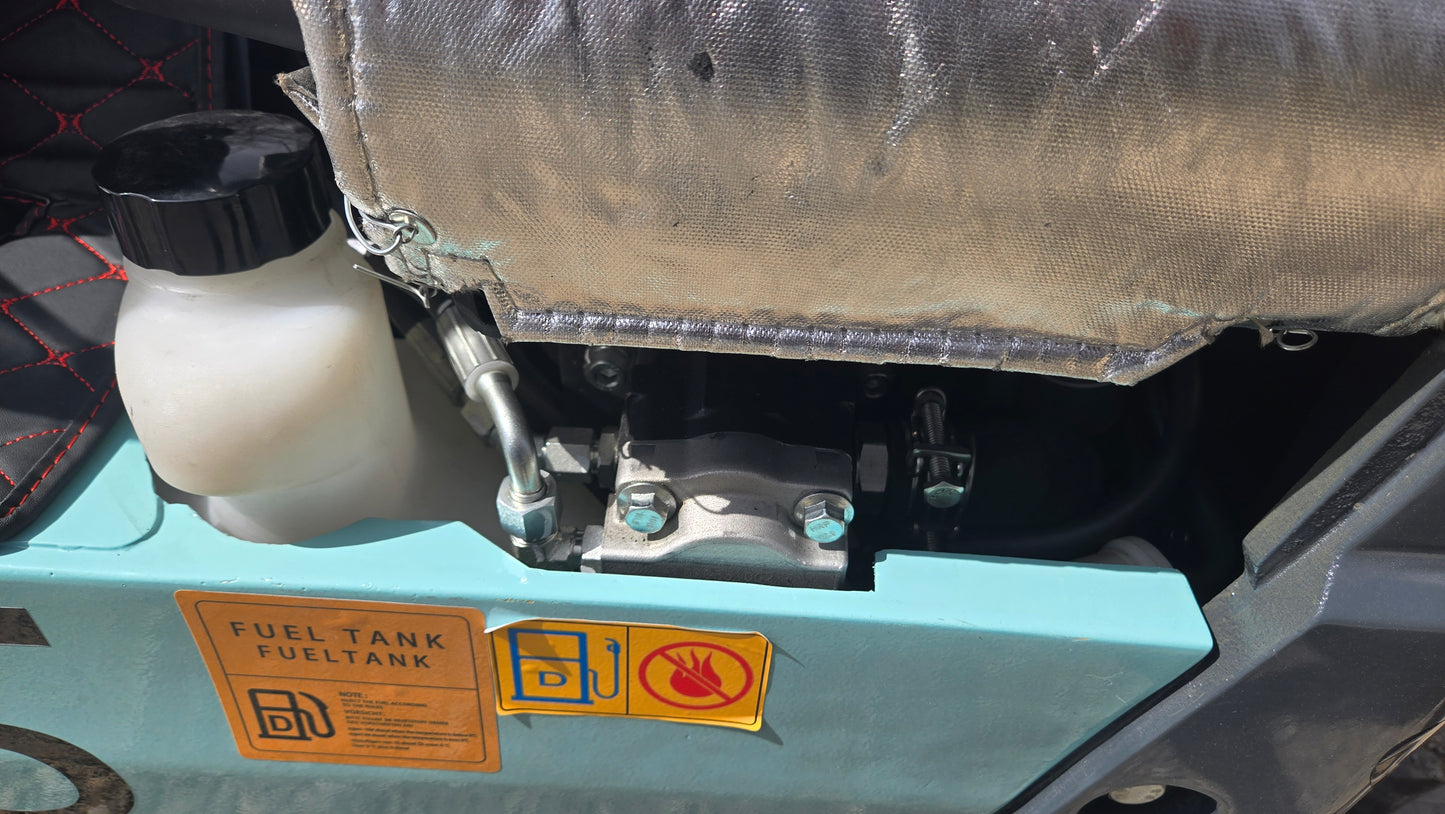 Close-up of JT5120P mini excavator fuel tank with warning label and fluid reservoir.