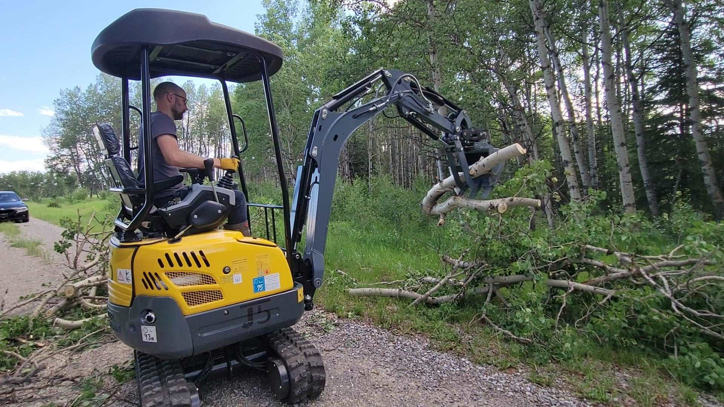 JoyT5 JT5200 2 ton mini excavator with Kubota D902 engine lifting logs using hydraulic thumb. Compact zero-tail digger with U-boom, side swing boom, and extendable undercarriage for construction and landscaping.
