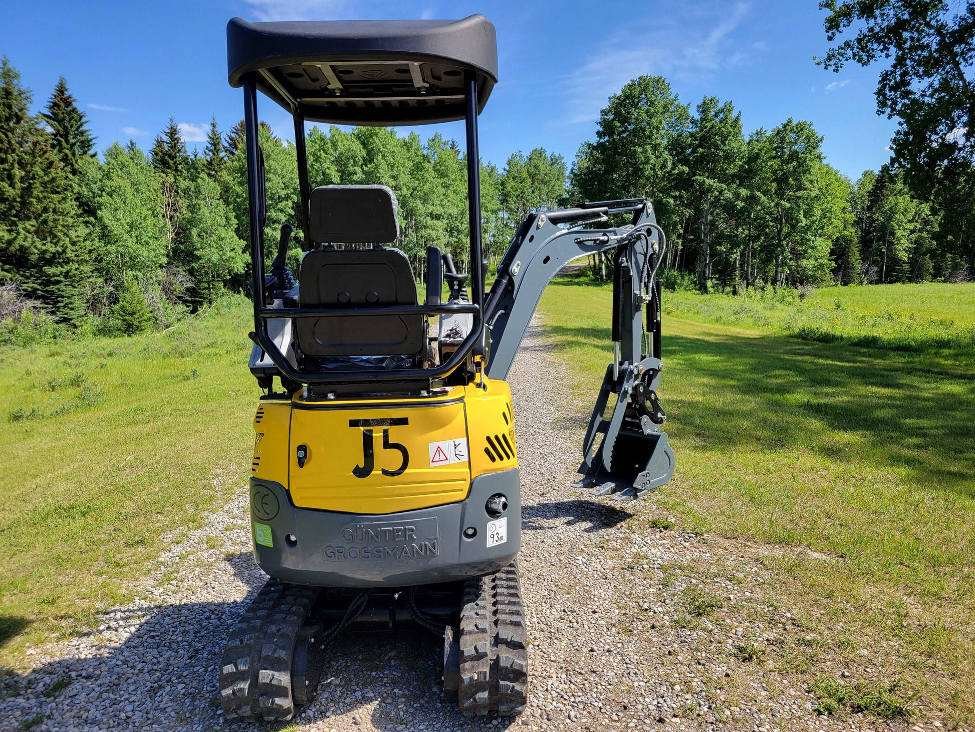 JoyT5 JT5200 mini excavator rear side view showing operator seat, canopy, rubber tracks, and digging arm with bucket.