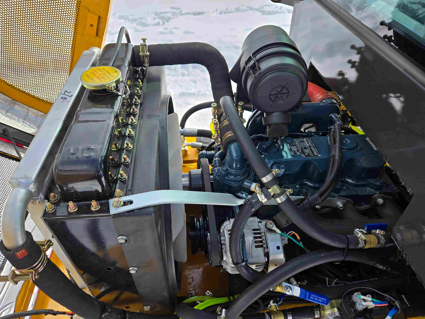 JT5WL1000 compact wheel loader 1 ton 2200 lbs for sale in Canada showing close-up of engine, radiator, and air filter system.