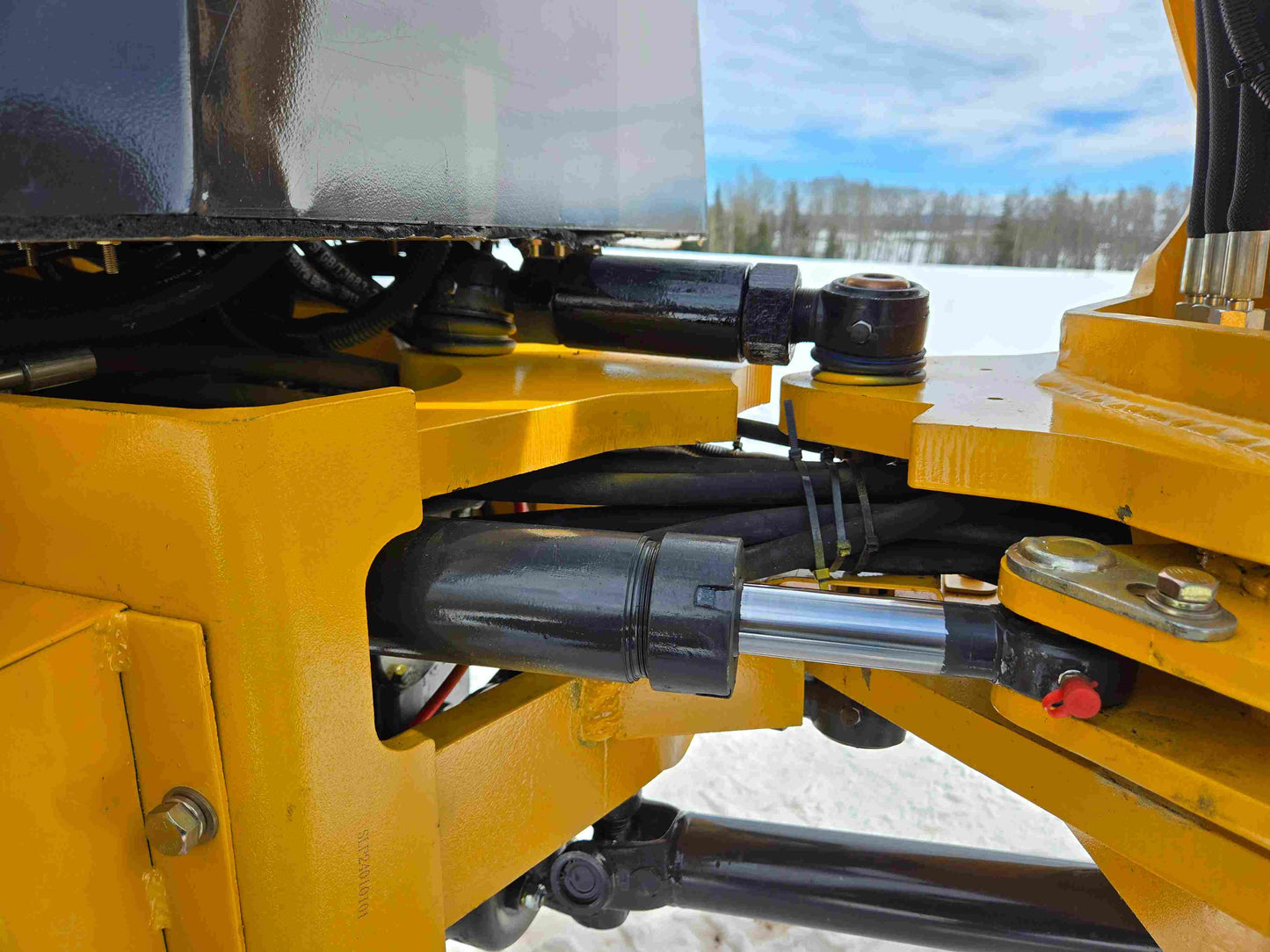 Close-up of JT5WL1000 wheel loader hydraulic steering cylinder and pivot joints.