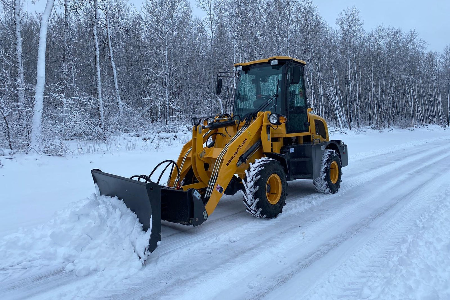 JT5WL1200 compact wheel loader 1.2 ton 2650 lbs for sale in Canada, yellow mini wheel loader clearing snow on winter road, durable construction and farm equipment.