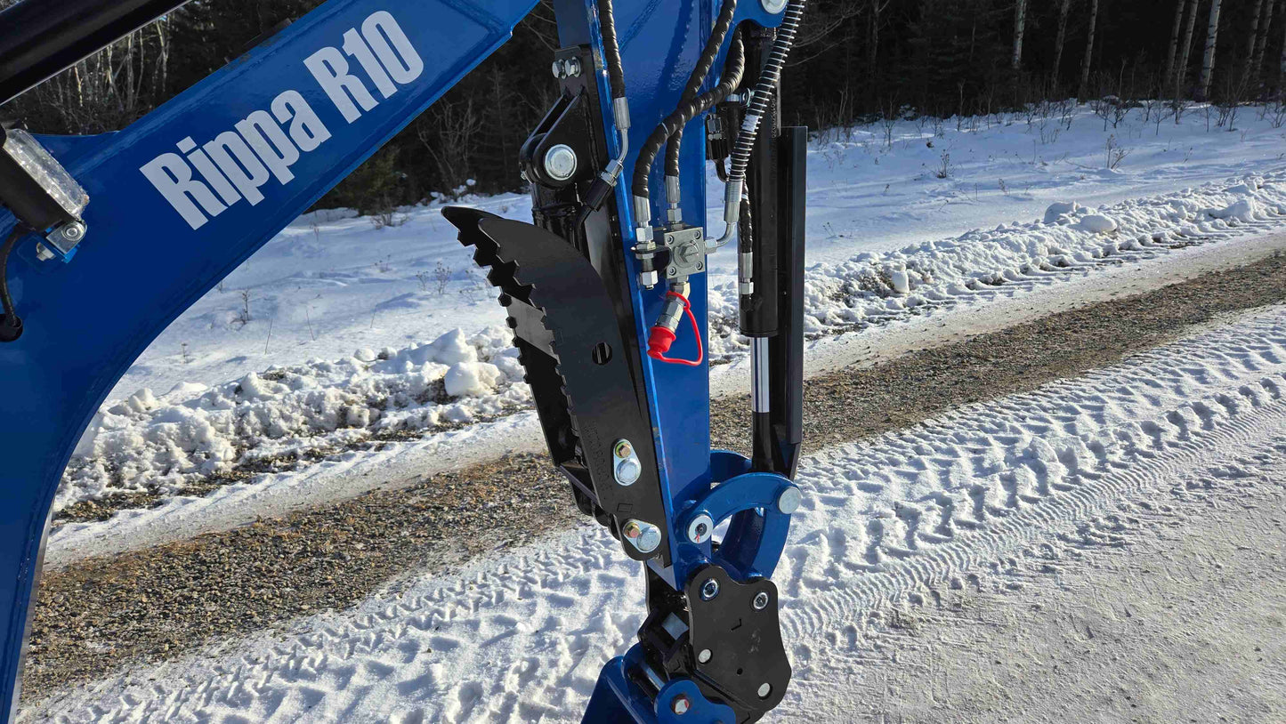 Close-up of Rippa R10 Mini Excavator hydraulic thumb attachment on snowy road