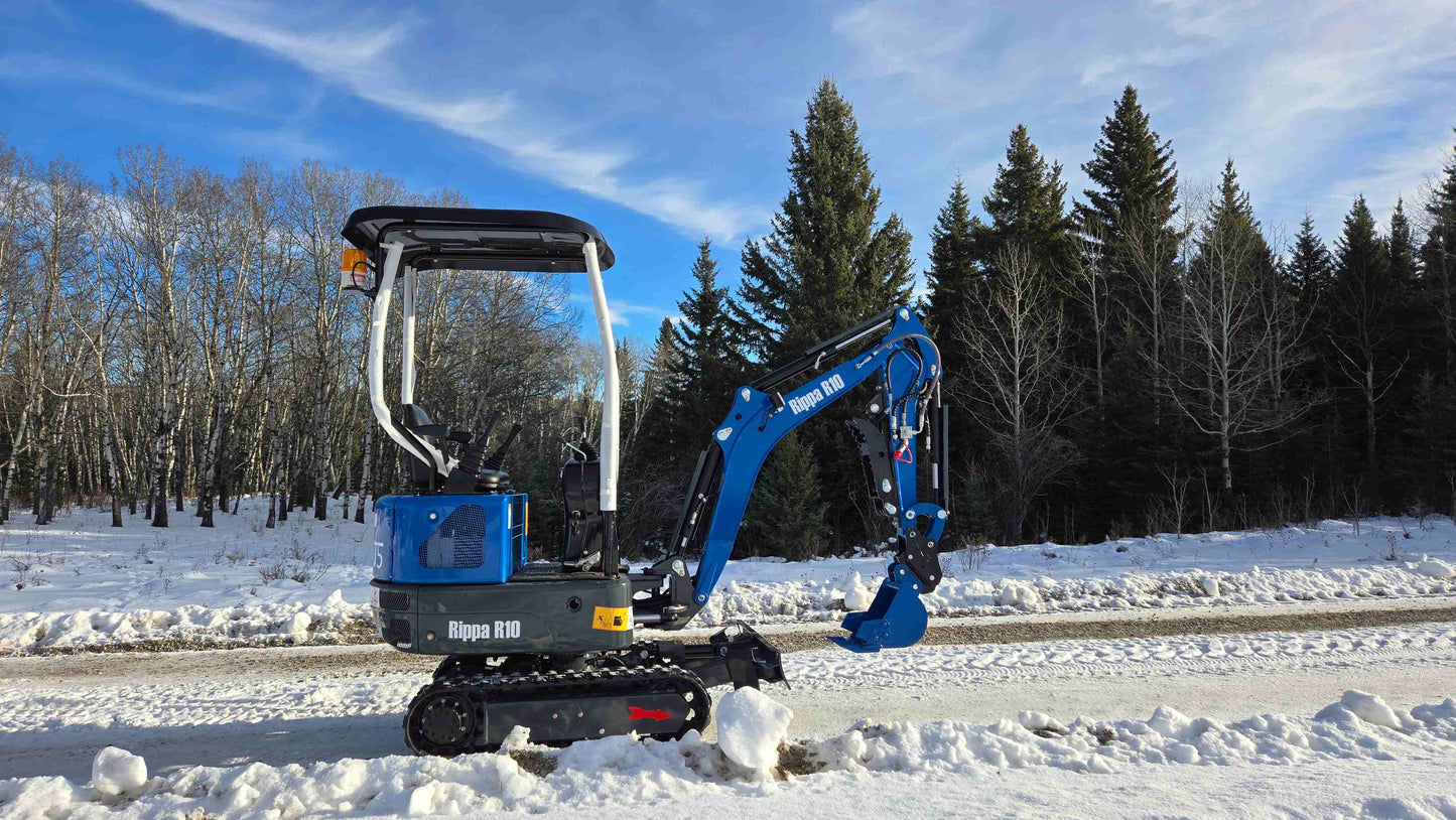 Rippa R10 Mini Excavator on snowy road with digging bucket raised in mid position
