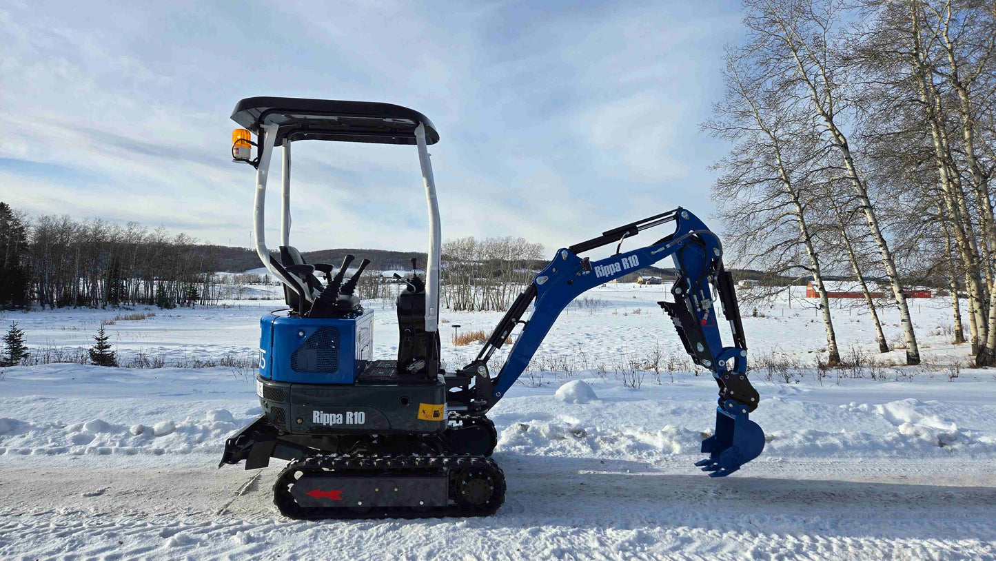 Rippa R10 Mini Excavator on snowy road with lowered boom in winter landscape