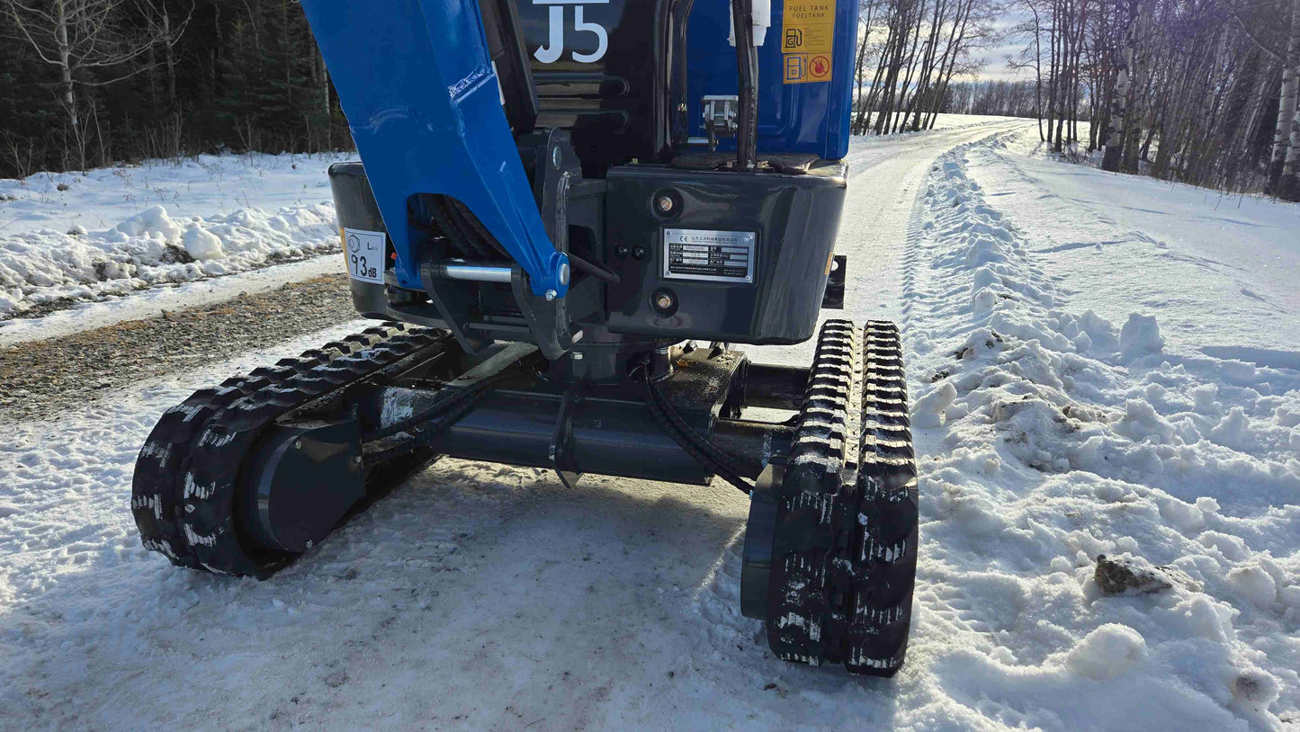 Close-up of Rippa R10 Mini Excavator undercarriage and rubber tracks on snowy road