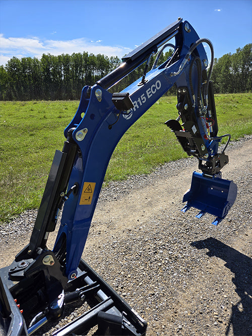 Closeup of Rippa R15 mini excavator arm with digging bucket on gravel road