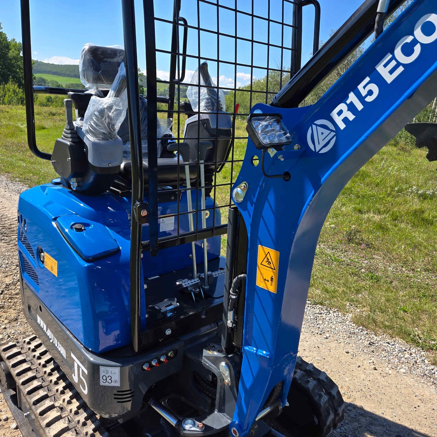 Close-up view of Rippa R15 Mini Excavator For Sale showing operator seat, control levers, and detailed machine parts on outdoor site.