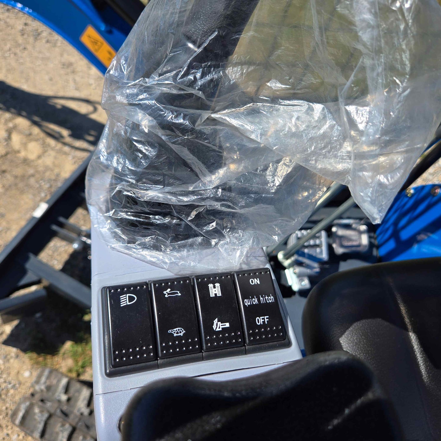 Close-up view of Rippa R15 Mini Excavator control panel with switches for lights, quick hitch, and other functions.