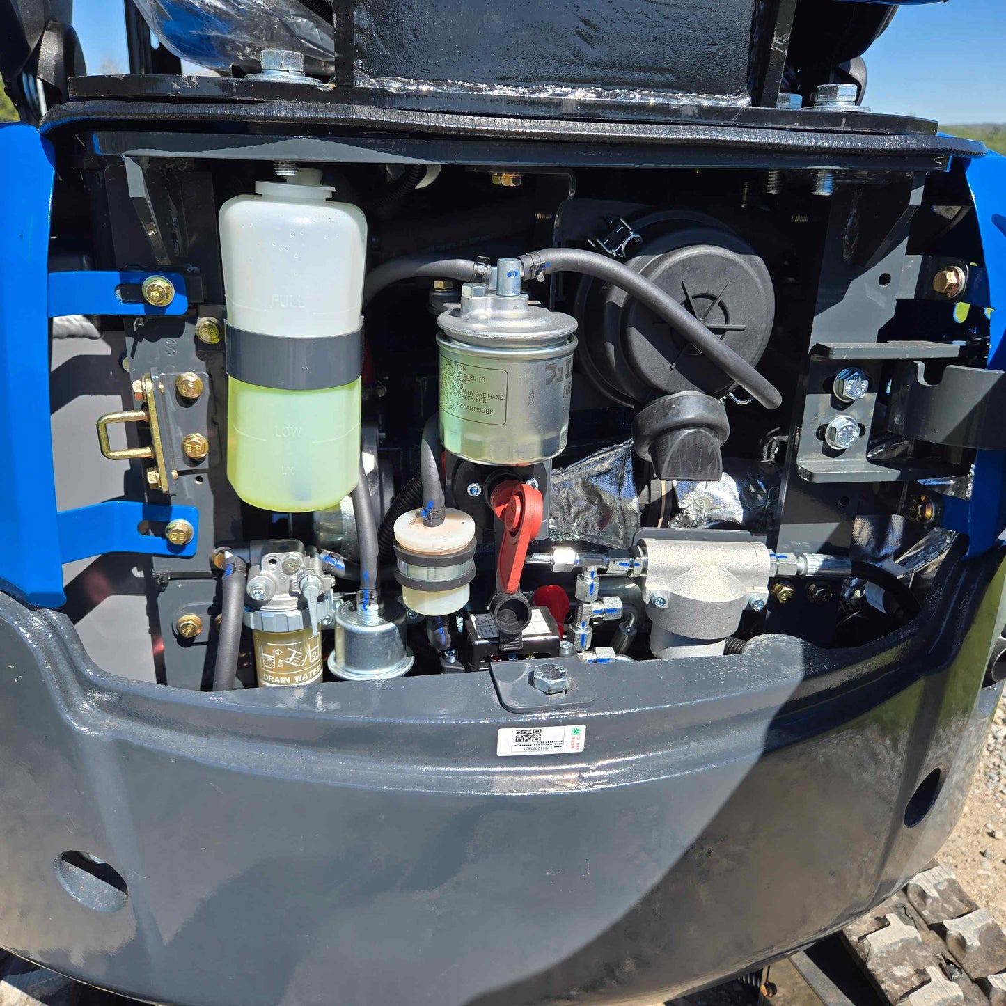 Engine compartment of the Rippa R15 Mini Excavator showing filters, fluid reservoir, and fuel system components.