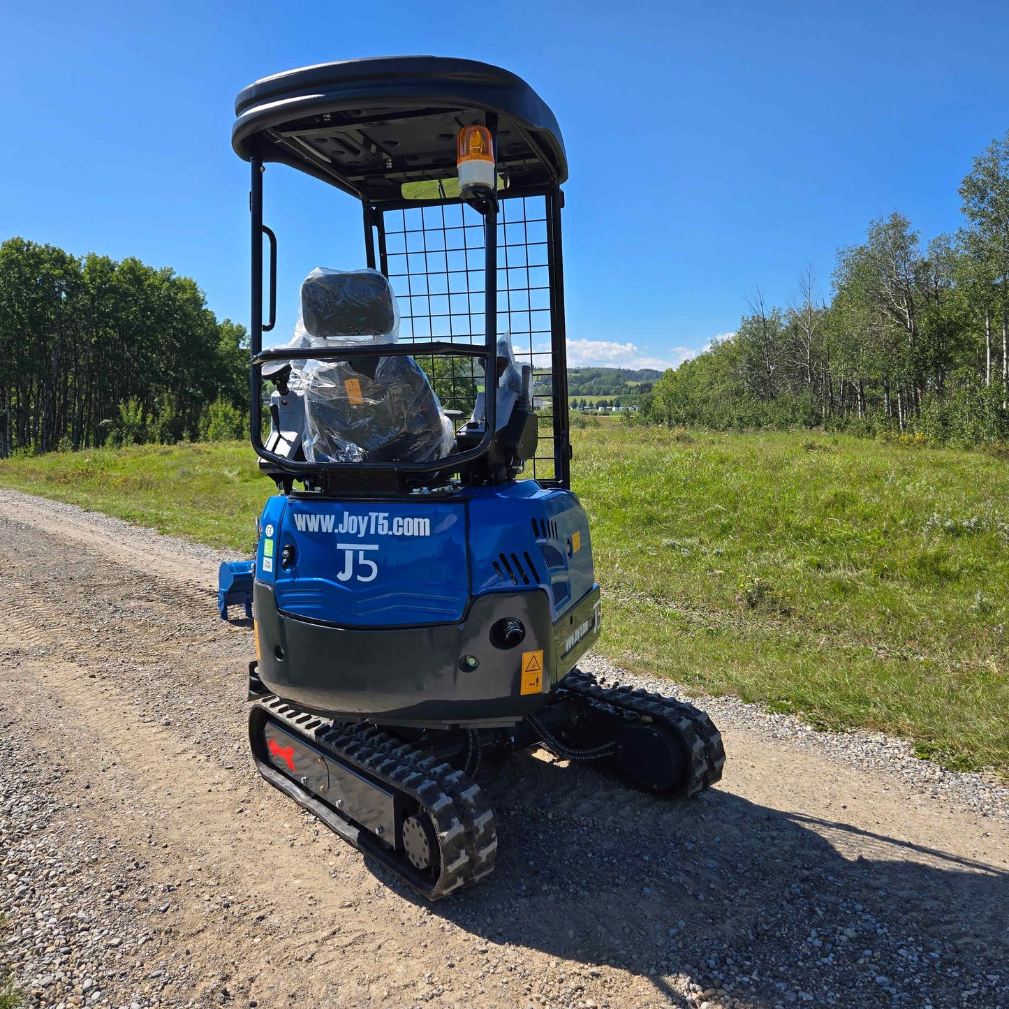 Rippa R15 Mini Excavator For Sale – compact excavator back view parked on a gravel rural road.