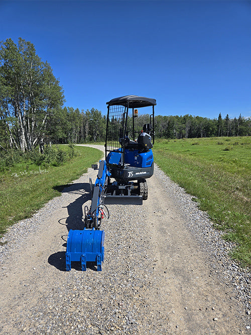 Rippa R15 mini excavator for sale rear view with extended bucket on rural gravel road