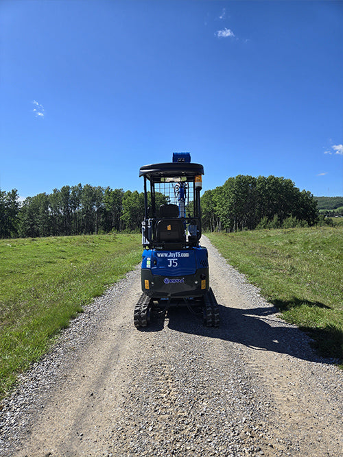 Rippa R15 mini excavator rear view on gravel road in green field