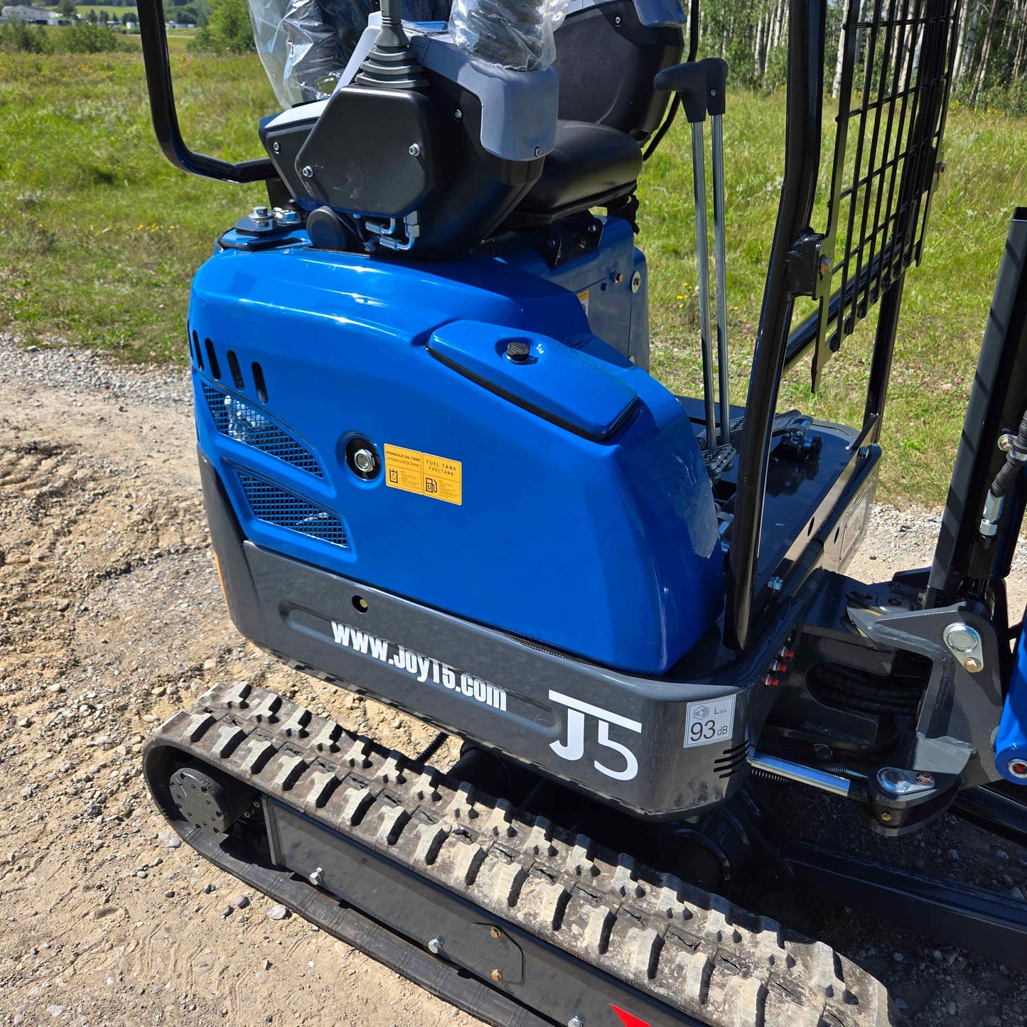 Side view of Rippa R15 Mini Excavator For Sale showing engine compartment, seat, and track system on outdoor construction site.