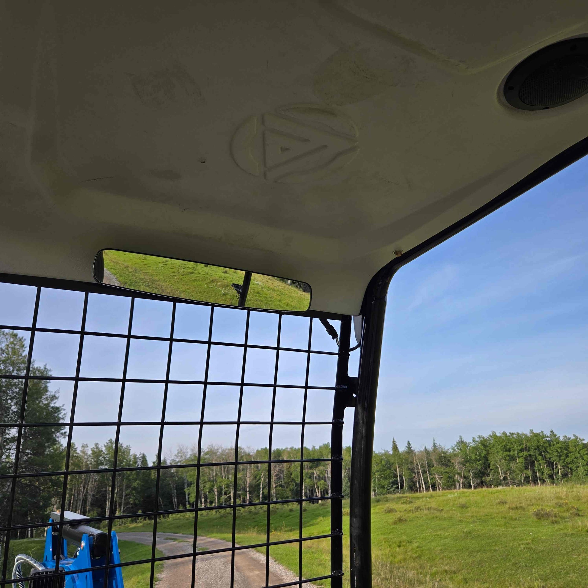 Interior cabin view of Rippa R18 mini excavator in Canada with safety grid and landscape background | Compact excavator JoyT5 for construction and landscaping work
