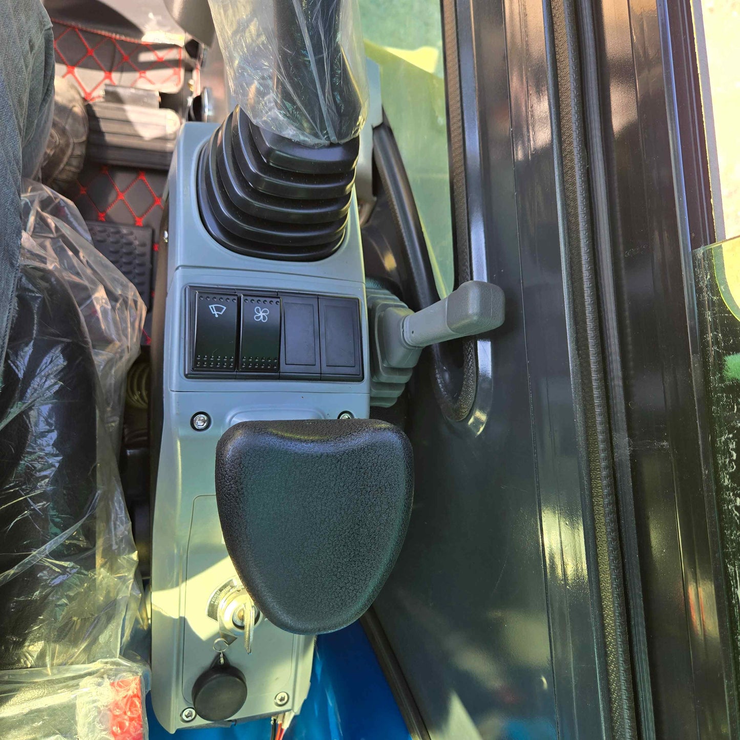 Close-up view of Rippa R22 Mini Excavator for sale control panel with joystick, switches, and ignition key.