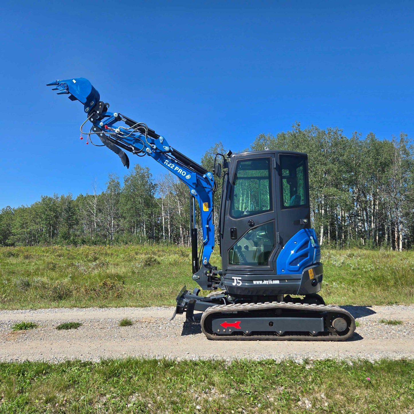 Rippa R22 Mini Excavator for sale full side view with raised bucket on outdoor gravel road.