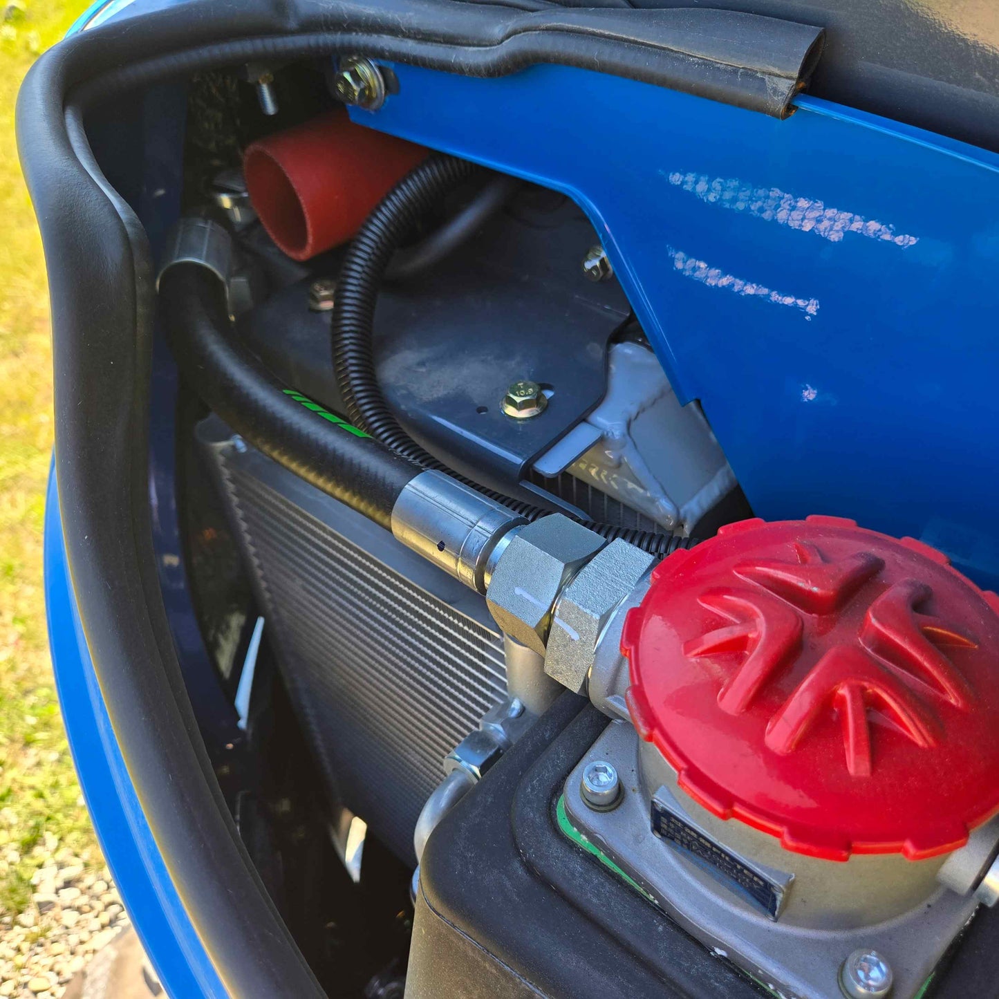 Rippa R22 Mini Excavator for sale hydraulic fluid reservoir with red cap, radiator hoses, and cooling system components inside engine bay.