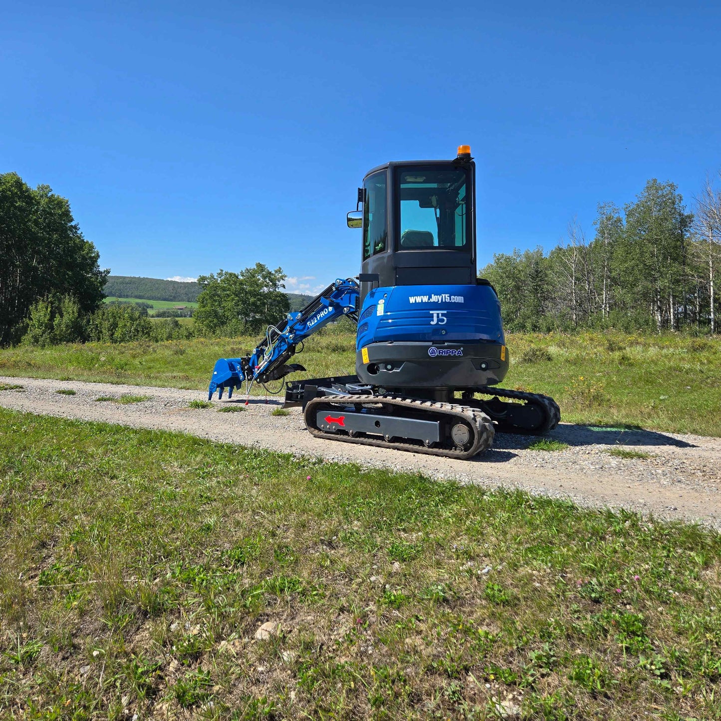 Rippa R22 Mini Excavator for sale rear view with digging arm lowered on gravel path.