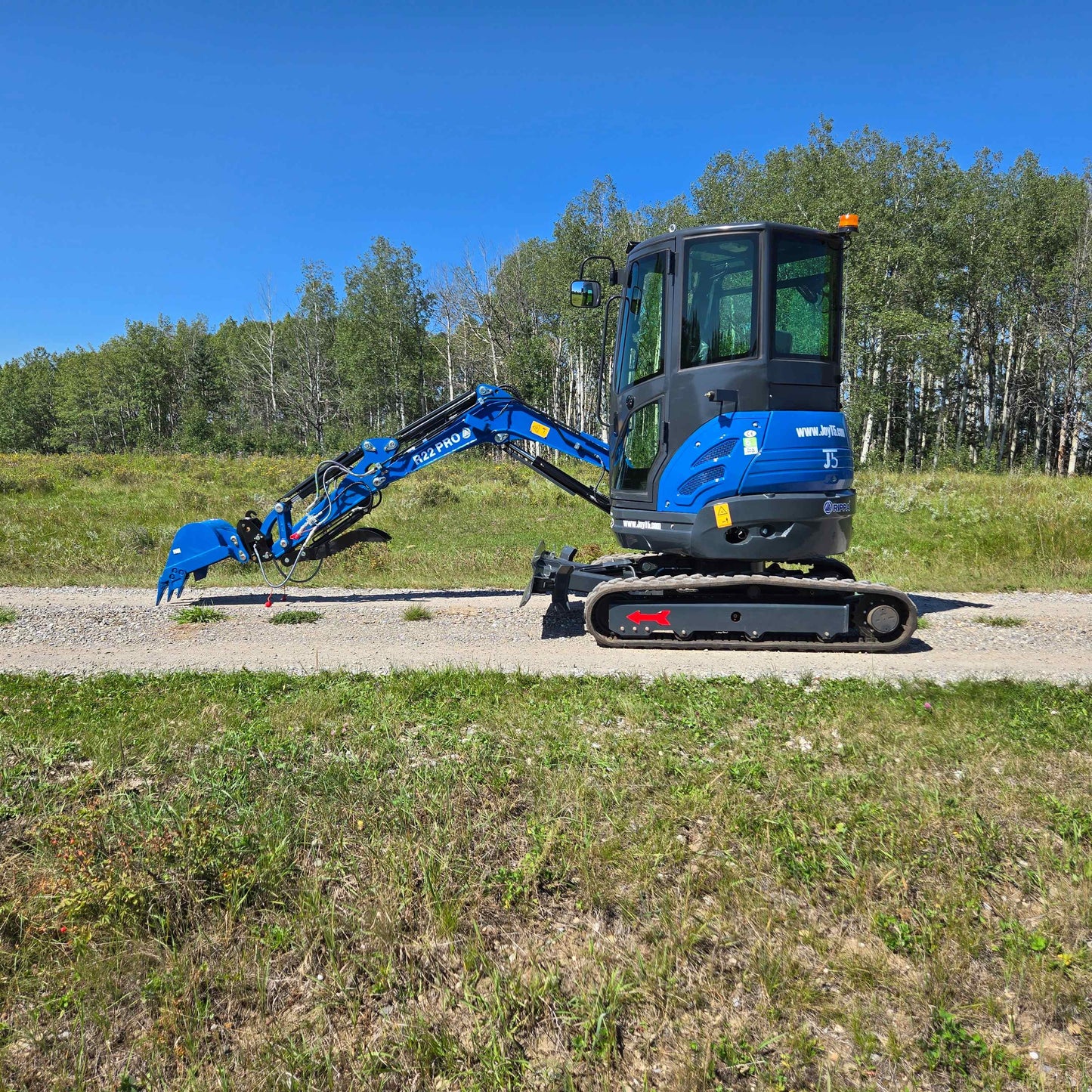 Rippa R22 Mini Excavator for sale side profile with digging arm lowered on gravel road.