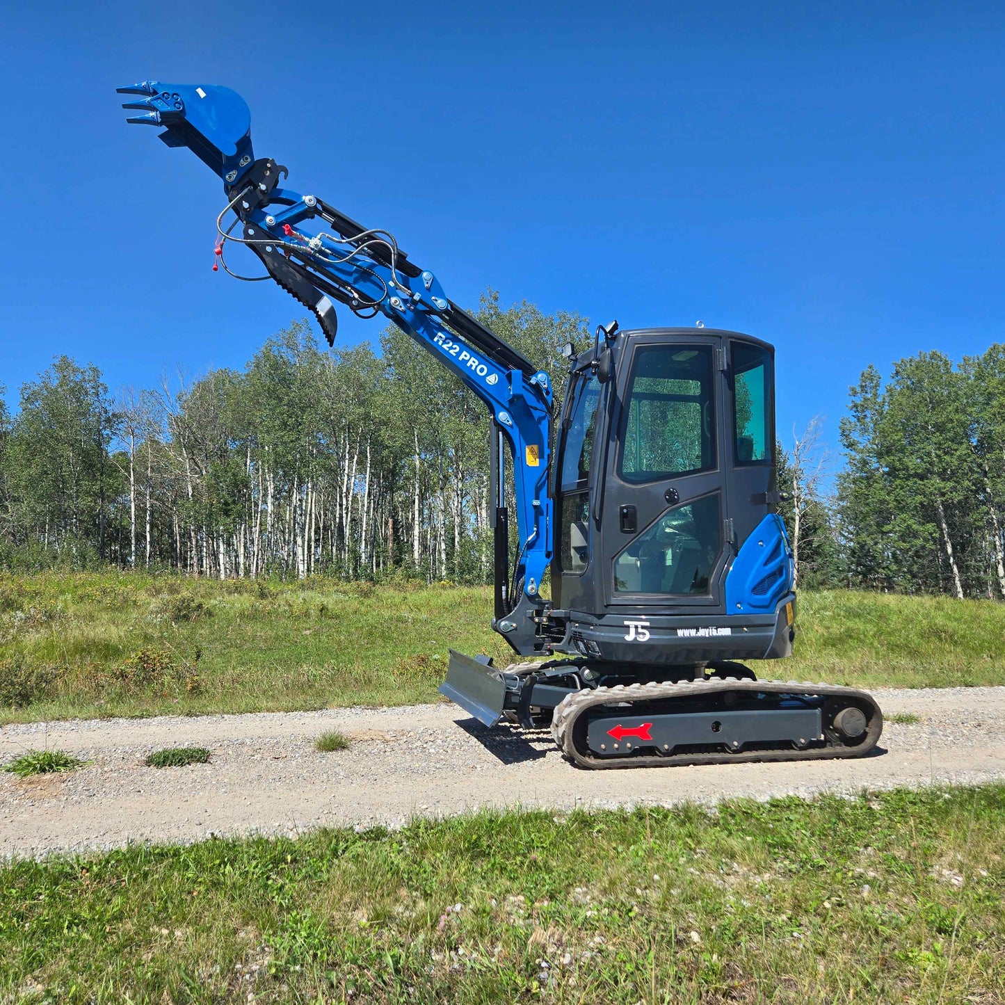 Rippa R22 Mini Excavator for sale side view with raised digging arm and bucket on gravel path.