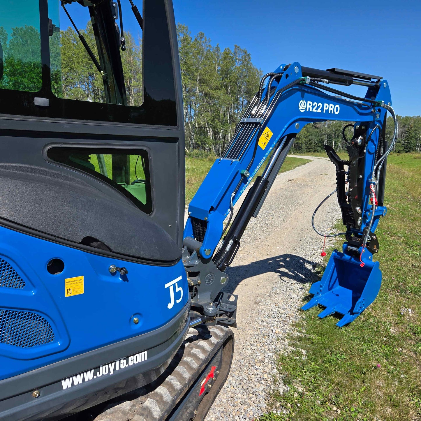 Side view of Rippa R22 mini excavator for sale showing boom, hydraulic arm, and digging bucket in working position.