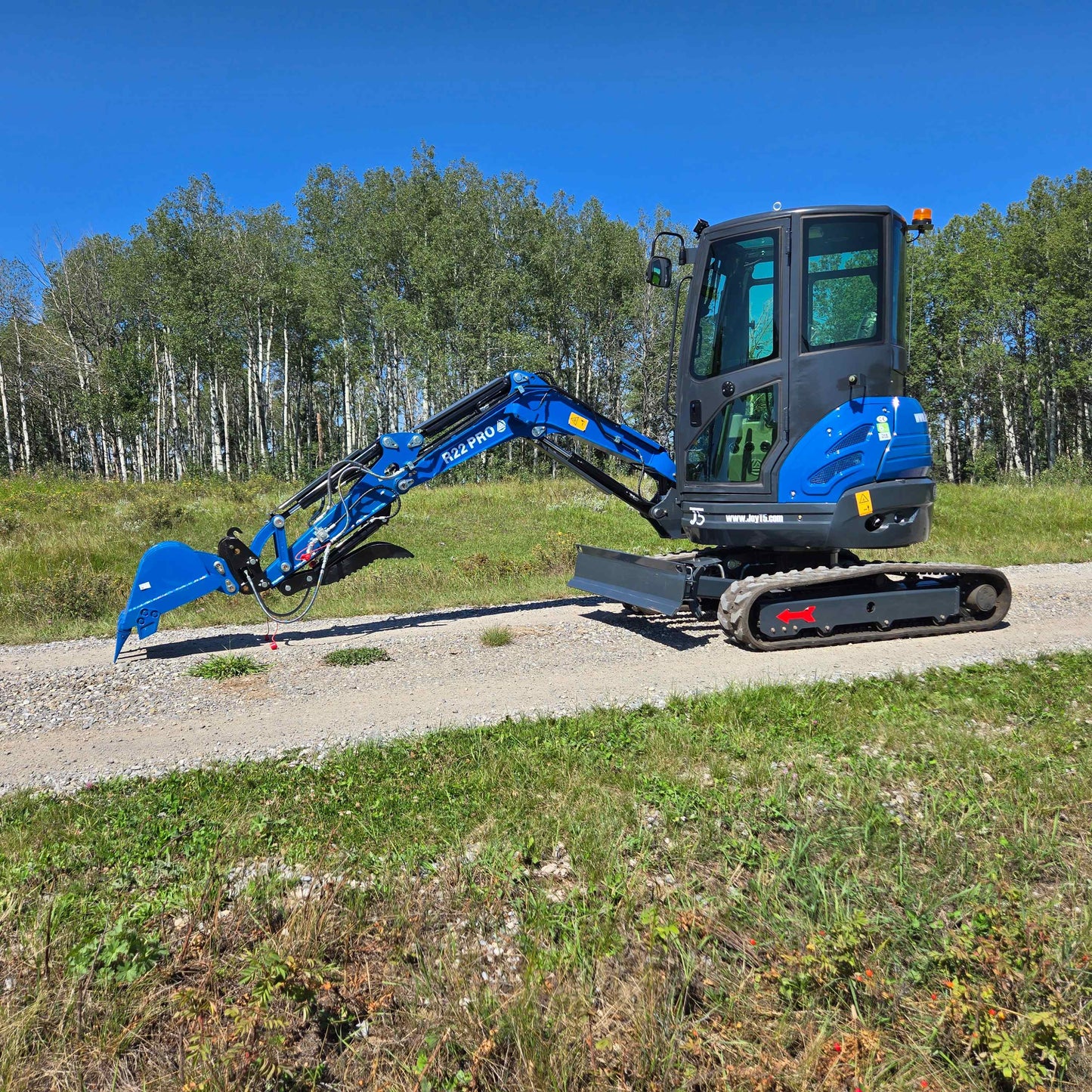 Rippa R22 Mini Excavator for sale side view with extended digging arm on gravel path.