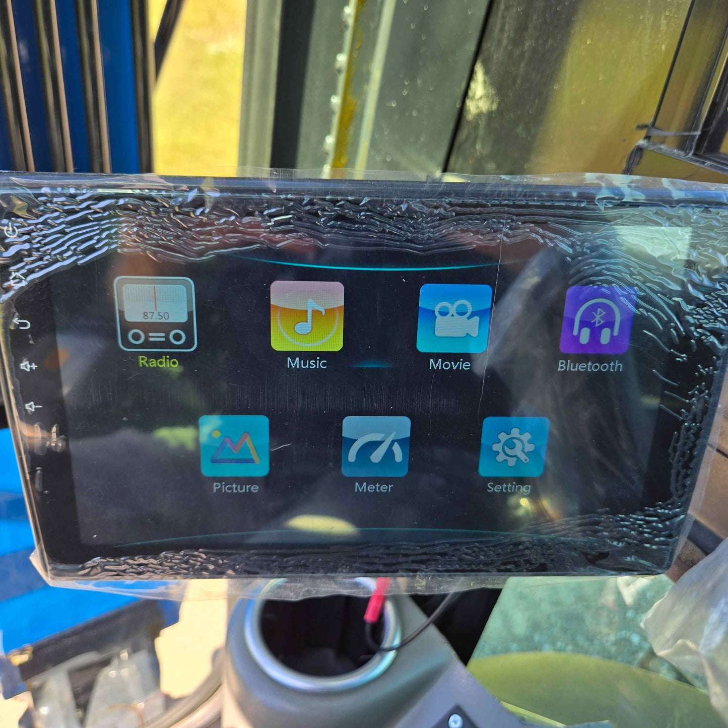 Touchscreen display of the Rippa R22 Mini Excavator for sale showing menu options including Radio, Music, Movie, Bluetooth, Picture, Meter, and Settings.