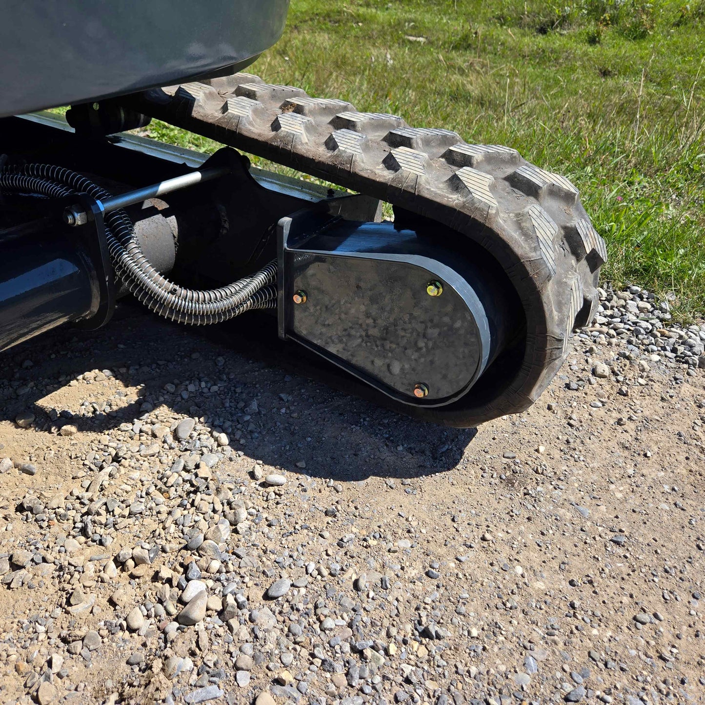 Close-up of the Rippa R22 Mini Excavator for sale rubber track and roller system on gravel.