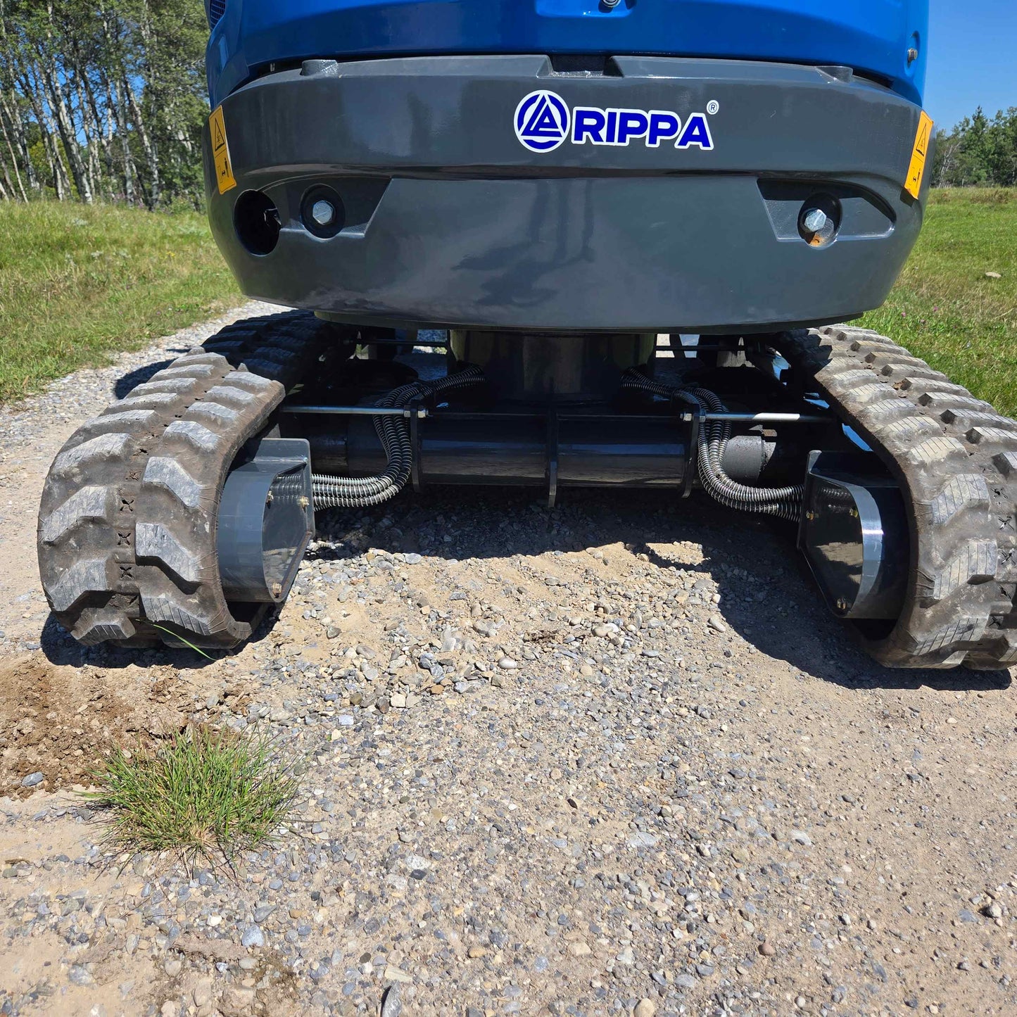 Close-up view of Rippa R22 Mini Excavator for sale tracks and undercarriage system on gravel ground.
