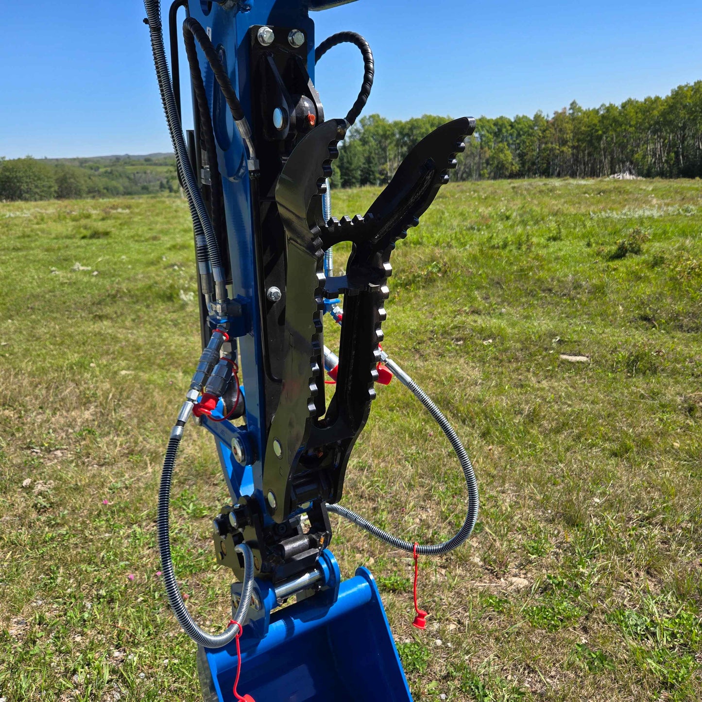 Hydraulic thumb attachment on the Rippa R22 Mini Excavator, for sale mounted on the boom for gripping and handling materials in the field.