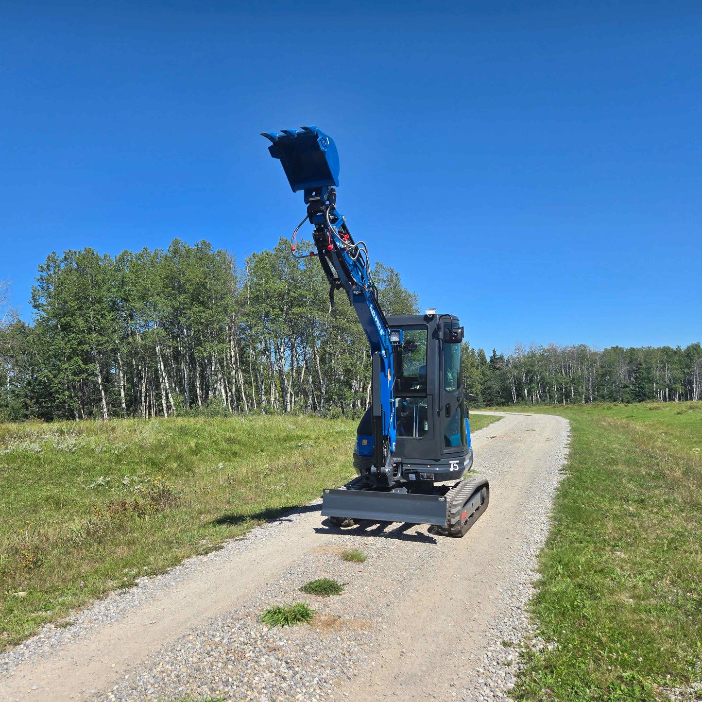 Rippa R22 Mini Excavator with front bucket lifted – Compact excavator working on rural road.