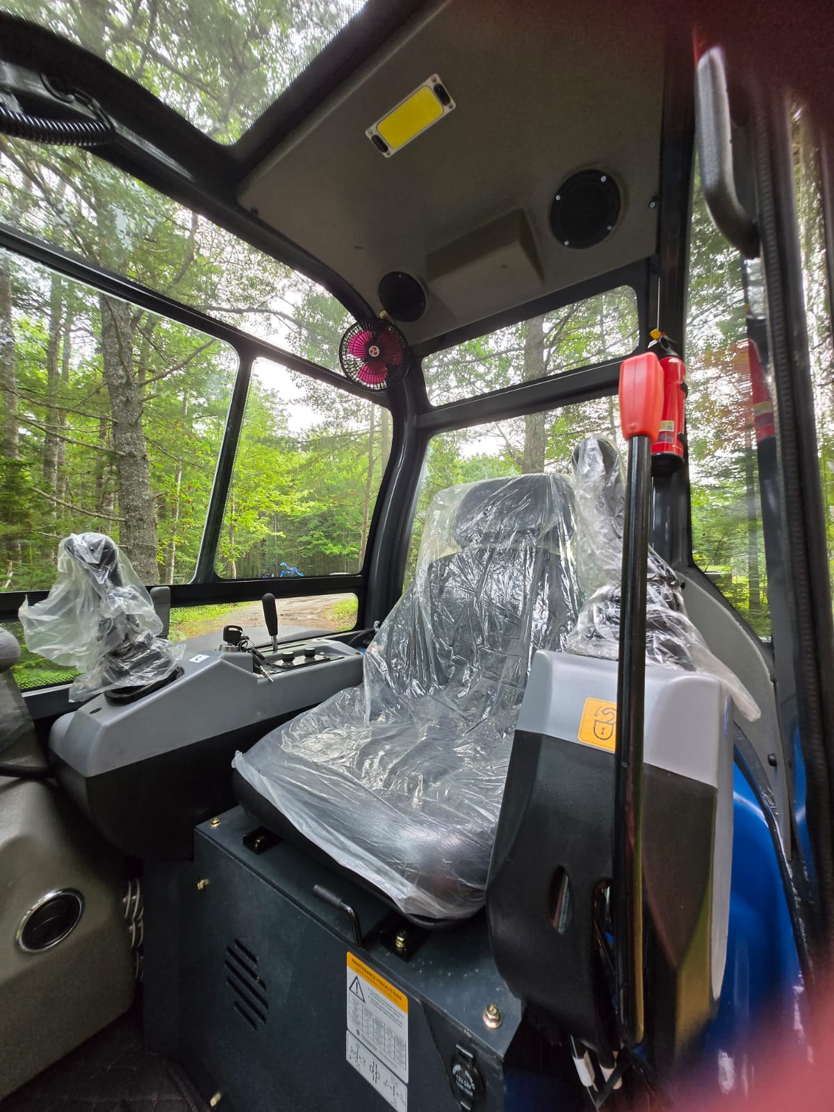 Cab interior of Rippa R32 Mini Excavator with operator seat, control levers, overhead fan, lighting, and fire extinguisher – JoyT5 Canada | JoyT5