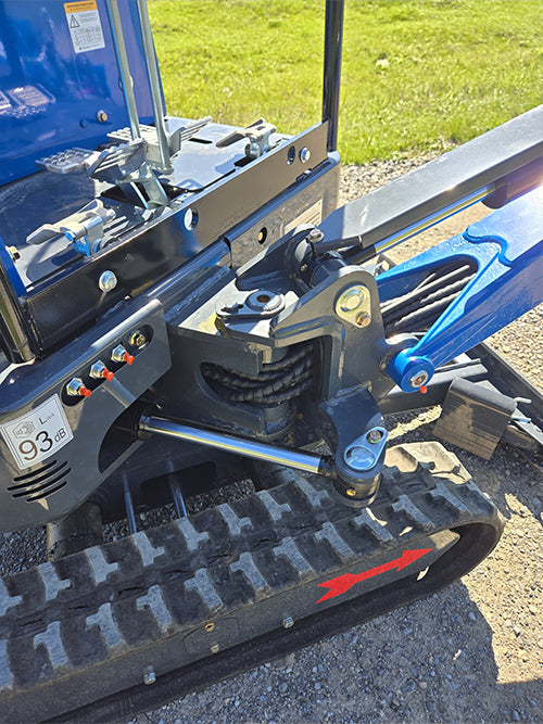 Close-up of rippa r15 mini excavator for sale undercarriage with rubber track, hydraulic arm, and red directional arrow
