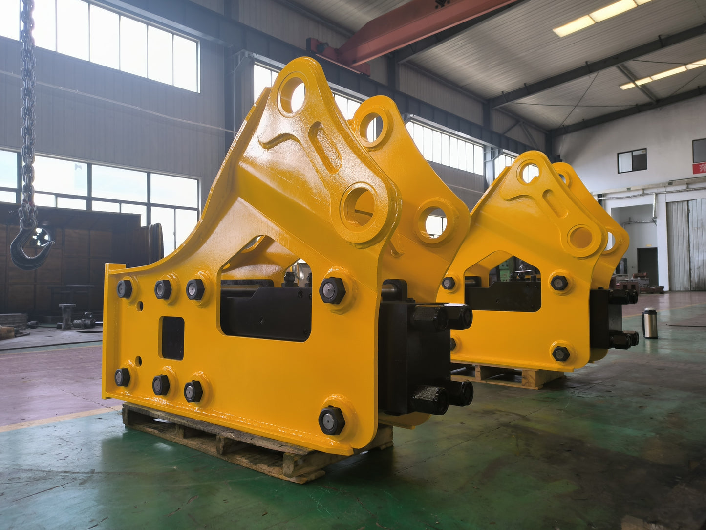 Yellow hydraulic breaker attachment for excavator, designed for demolition, quarrying and heavy construction projects.